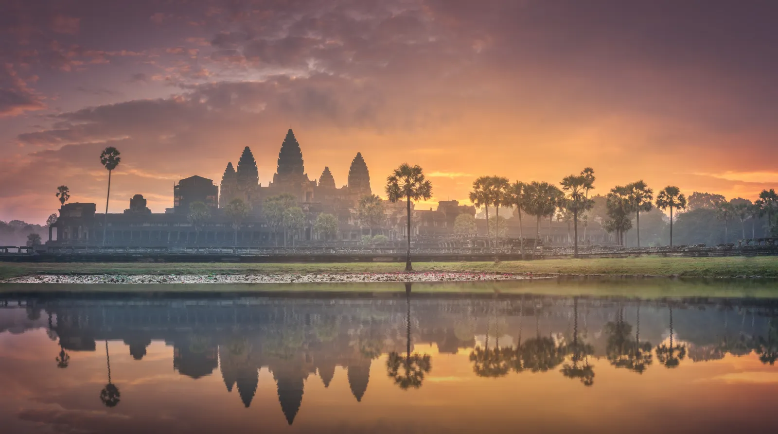 Soluppgång över Angkor Wat-templet i Kambodja speglat i vatten