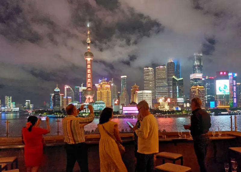 Kvällsvy över Shanghai med ensamresenärer från Rolfs Flyg & Buss vid vattnet