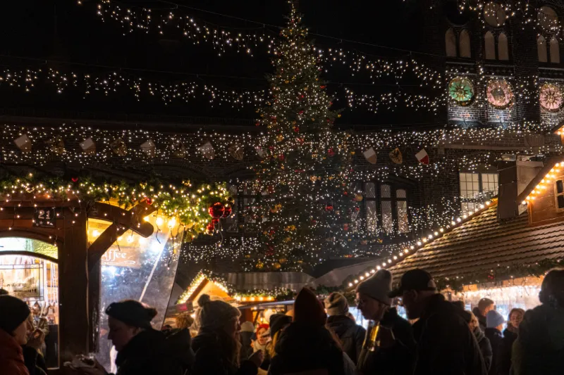 Stor julgran och julmarknad i kvällsmörker i Lübeck