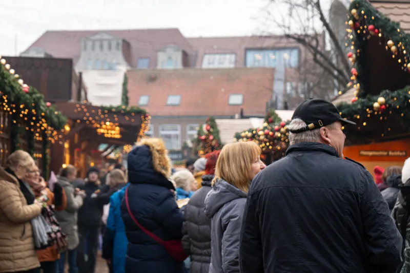 Folkvimmel bland julstånd på julmarknaden i Lübeck