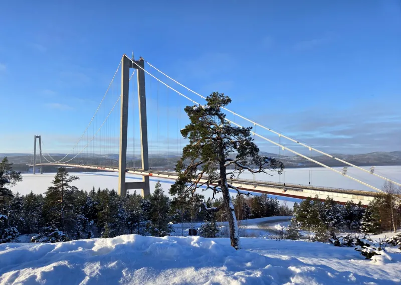 Högakustenbron täckt av snö under en solig vinterdag i norra Sverige