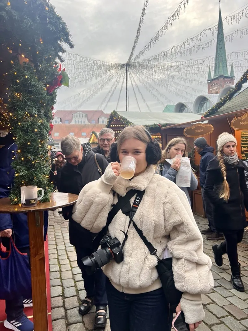 Person som dricker glühwein på julmarknad i Lübeck