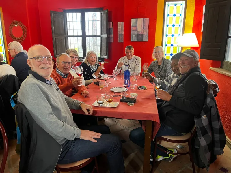 resesällskap samlat kring långbord under vinprovning