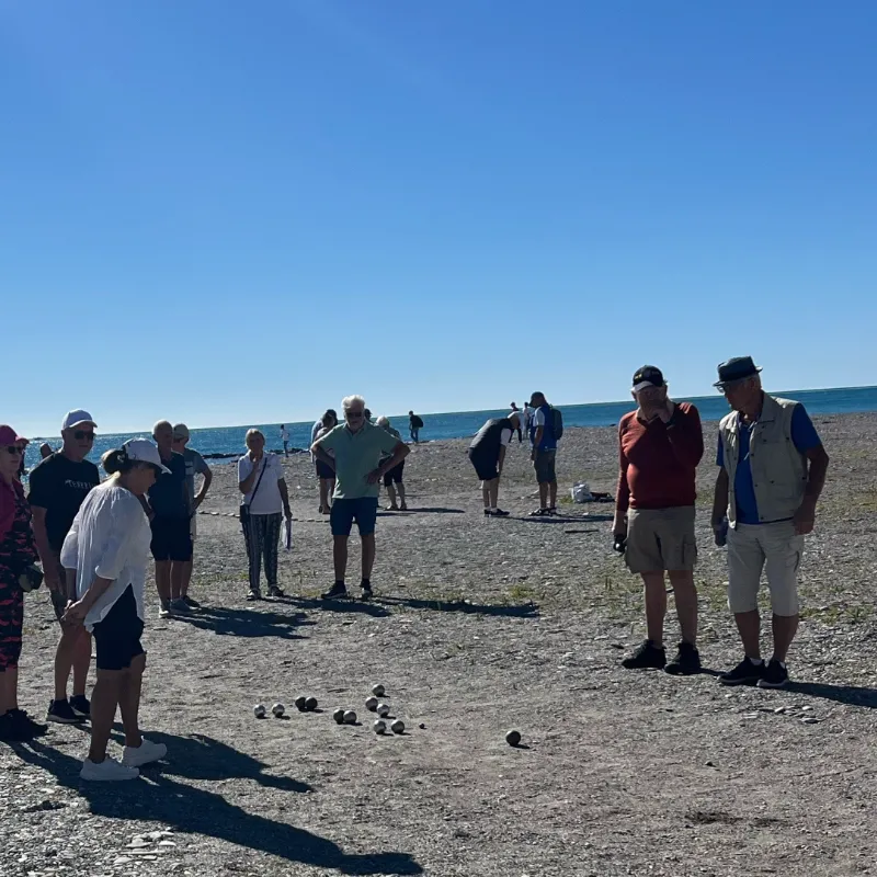 Resesällskap spelar boule vid havet under vistelse på Costa del Sol
