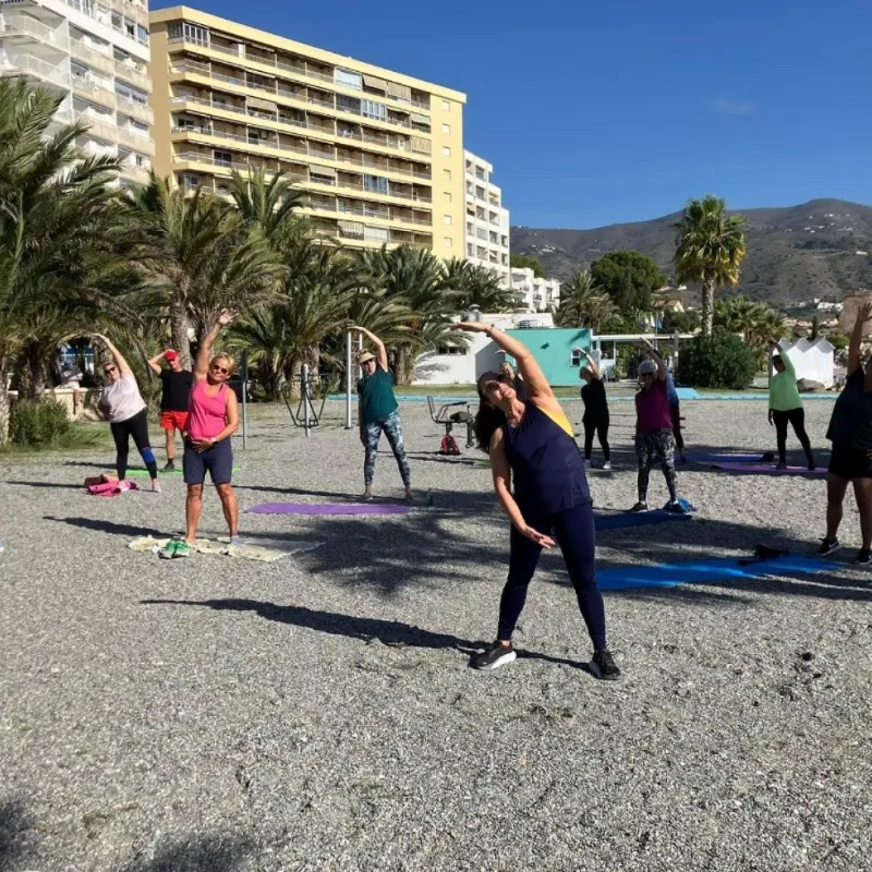 Resenärer tränar utomhus vid stranden under solig morgon i Spanien