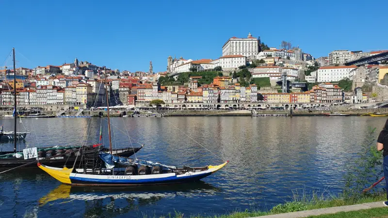Färgglada Porto och Dourofloden med traditionell portugisisk båt i förgrunden