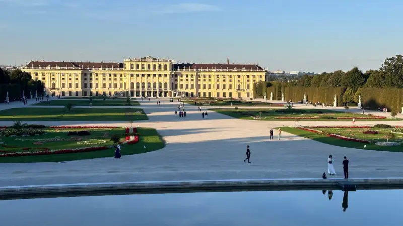 Slottet Schönbrunn med pampiga trädgårdar under solig dag i Wien