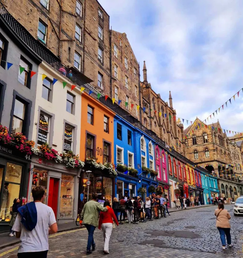 Färgglada hus och folkliv längs Victoria Street i Edinburgh i Skottland