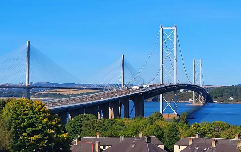 Forth Bridge sträcker sig över vattnet utanför Edinburgh under klarblå himmel