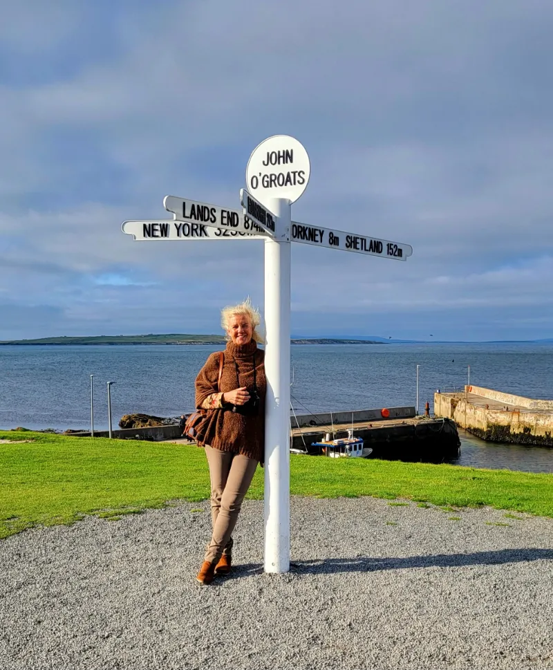 Resenär vid John O’Groats-skylten med havsutsikt i norra Skottland