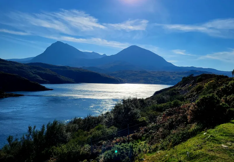 Solbelyst bergslandskap och havsvik i de skotska högländerna