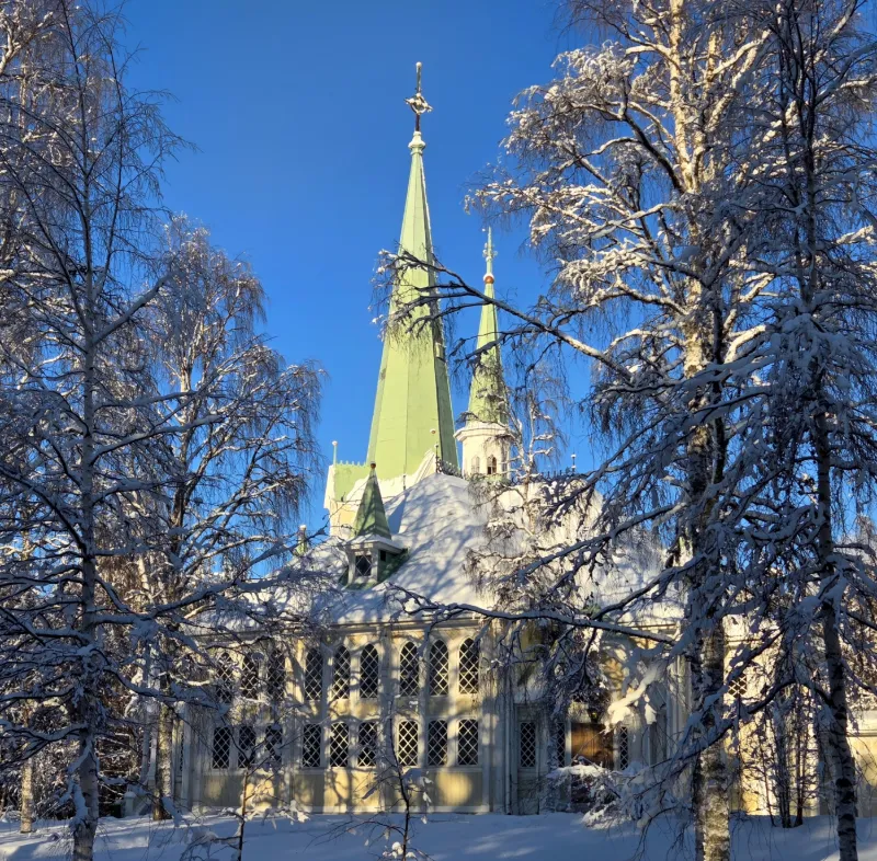 Kyrka omgiven av snötäckta träd under vinterdag i norra Sverige
