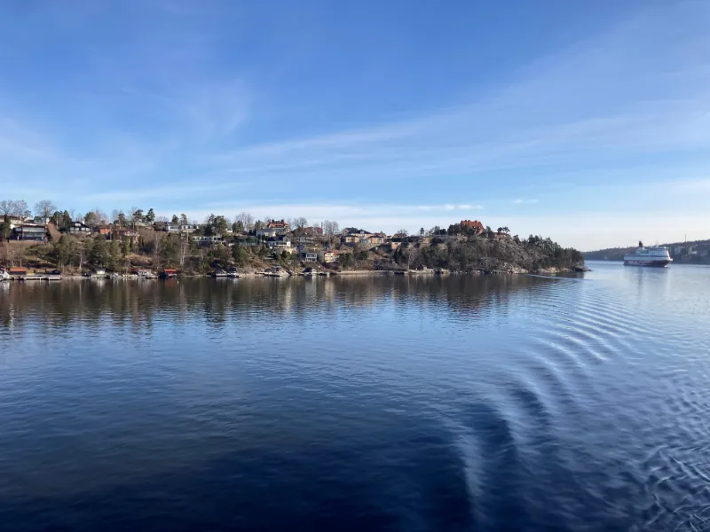 Lugn skärgårdsutsikt med spegelblankt vatten och blå himmel