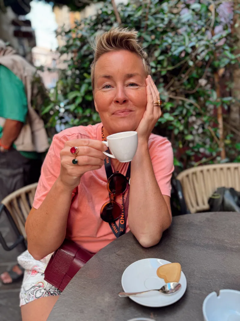 Theresa njuter av en espresso på en uteservering under resan i Italien