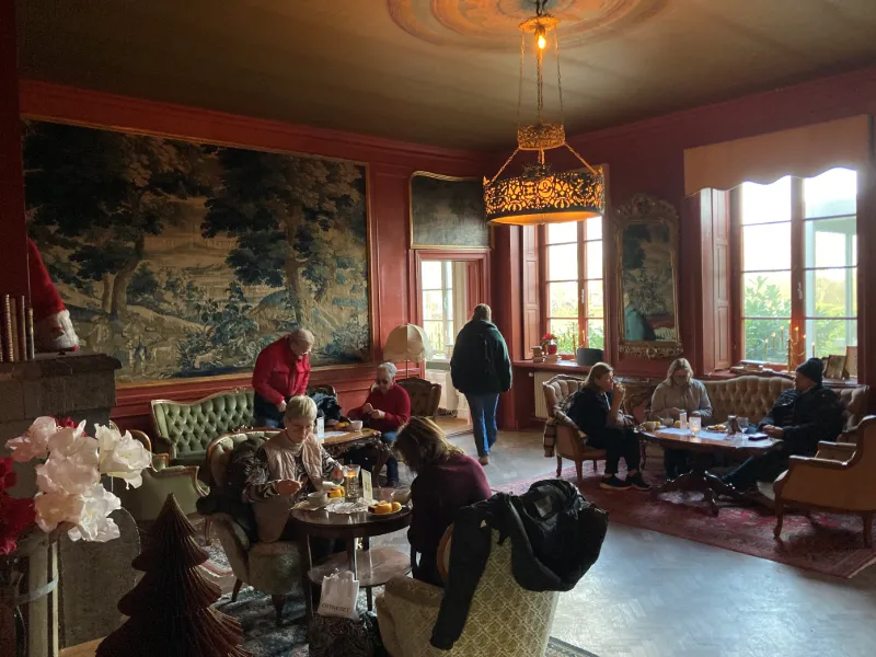 Mysig salong på Wapnö Slott med julstämning och besökare