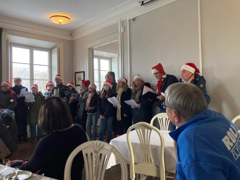 Körsång och besökare i slottsmiljö under julmarknad på Wapnö