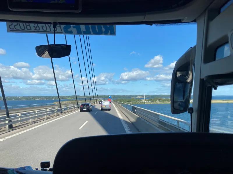 Bussresa över lång bro med havsutsikt och sommarkänsla