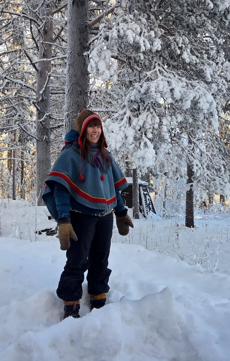 Samisk guide i vinterlandskap under besök i samebyn Silba Siida