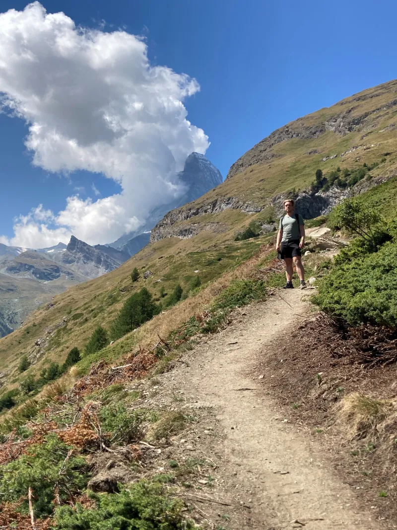 Vandring längs slingrande bergsstig med Matterhorn i bakgrunden