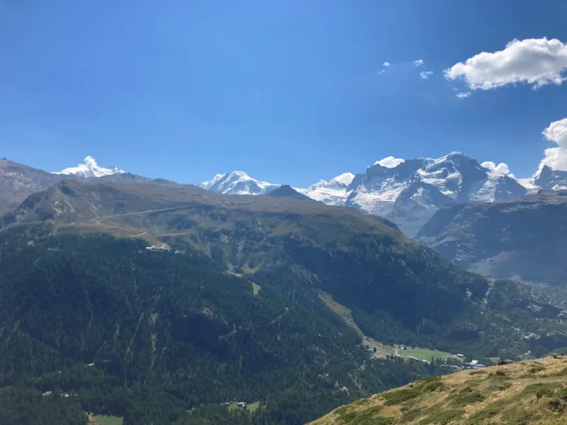 Snötäckta alptoppar och glaciärer under klarblå himmel