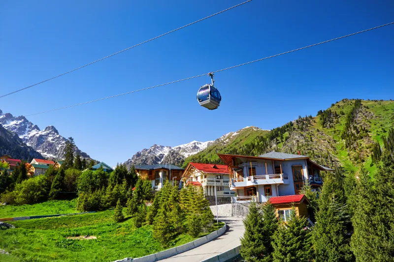 Linbana över grön dal och bergslandskap i Centralasien.