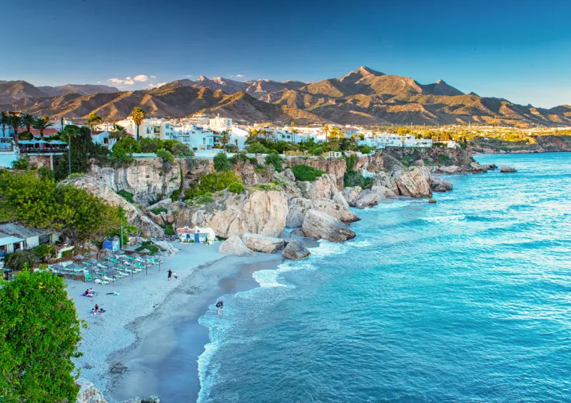 Kustvy över Nerja med klippor, strand och Medelhavet