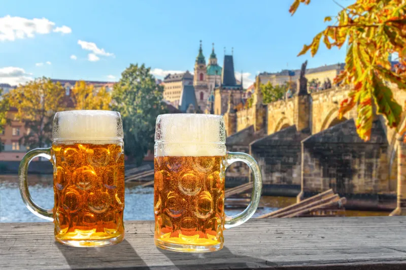 Två glas tjeckisk öl med Prag i bakgrunden.