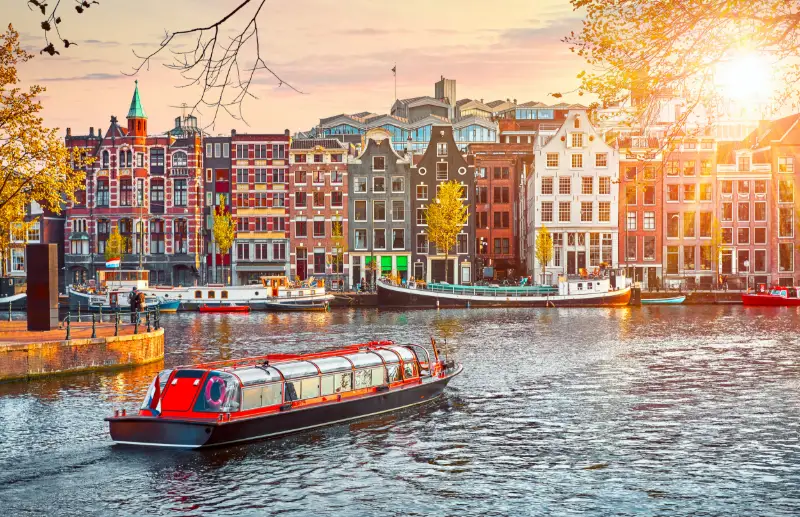 1. Kanalbåt bland historiska hus i Amsterdam.