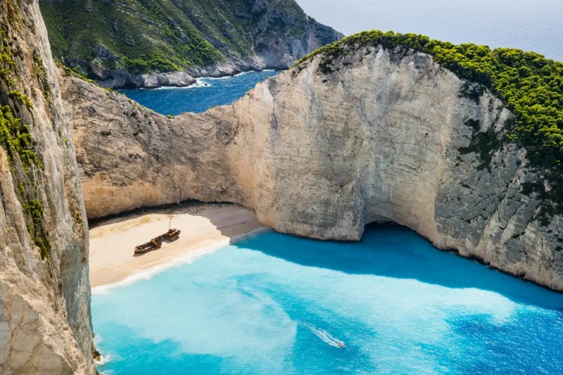 Navagio Beach på Zakynthos med turkost vatten, vit sandstrand och ett skeppsvrak omgivet av höga kalkstensklippor