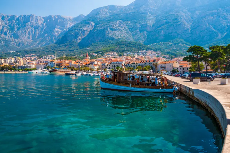 Vy över hamnstaden Makarska med traditionella båtar i det kristallklara Adriatiska havet