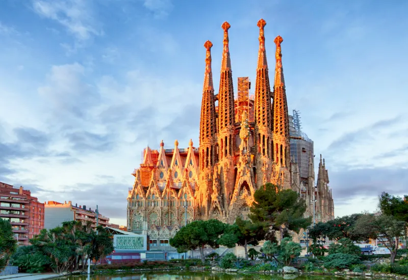 Sagrada Família i Barcelona upplyst av kvällssolen under en klar himmel.