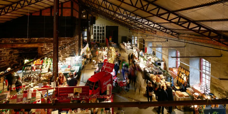 Julmarknad på Huseby Bruk med marknadsstånd i historisk bruksmiljö